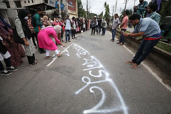 Students paint a slogan on Sylhet street